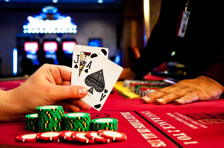 A game of blackjack chips jack and ace of spades on the hands